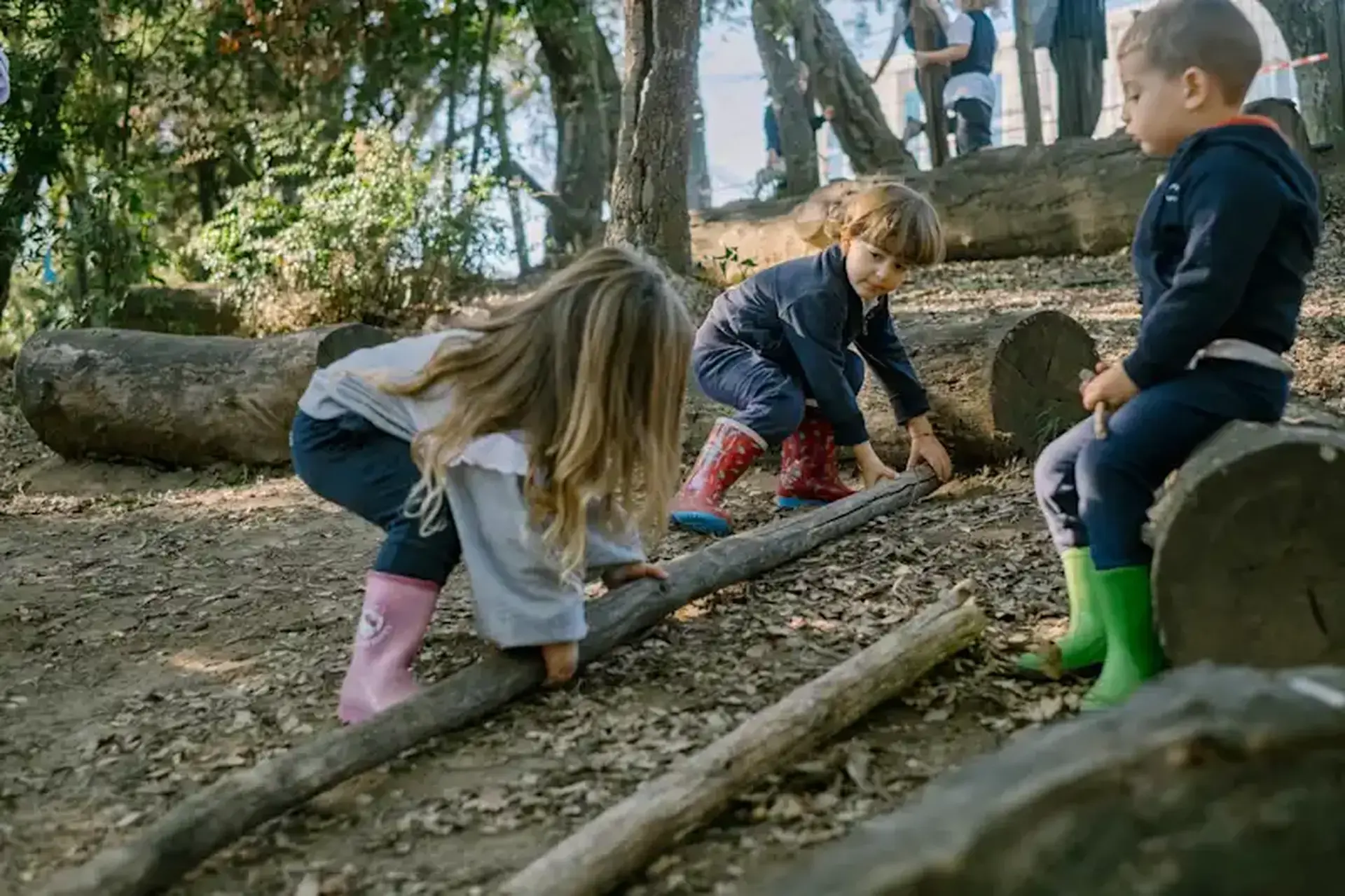 student climbing over a fallen log outdoors during an activity.