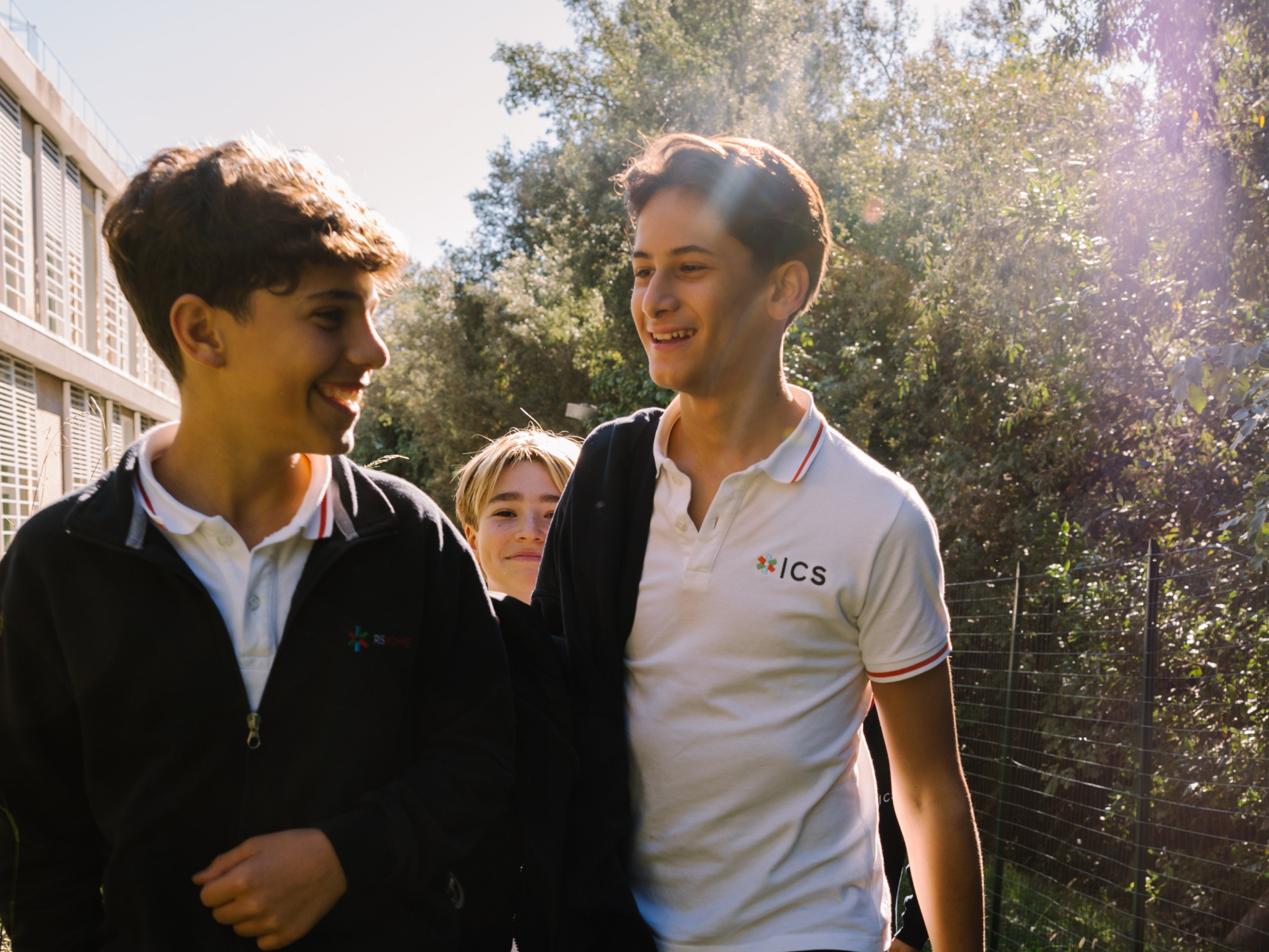 students laughing together outdoors on campus