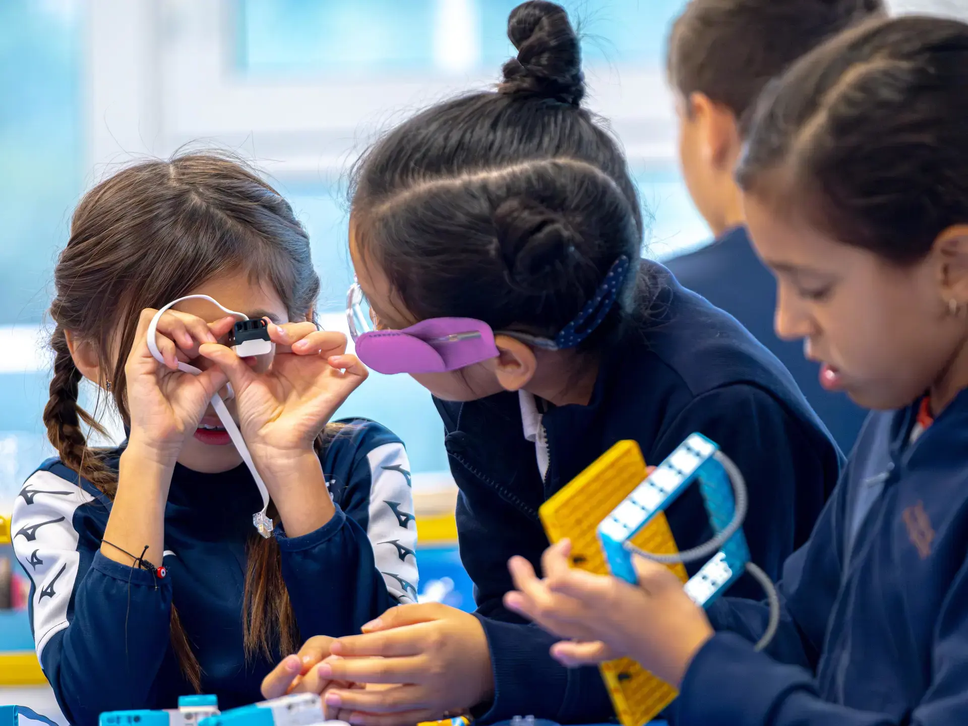 students building and testing electronic devices together during a stem class