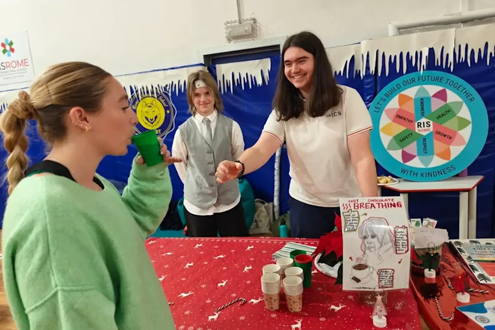 teacher and student shaking hands in front of a classroom activity display.