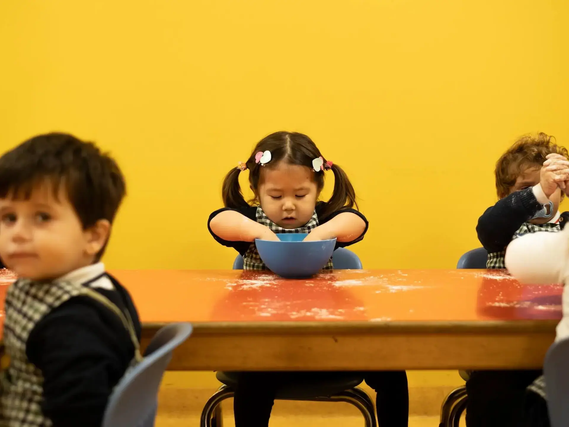 young student mixing ingredients in a bowl during a classroom cooking activity