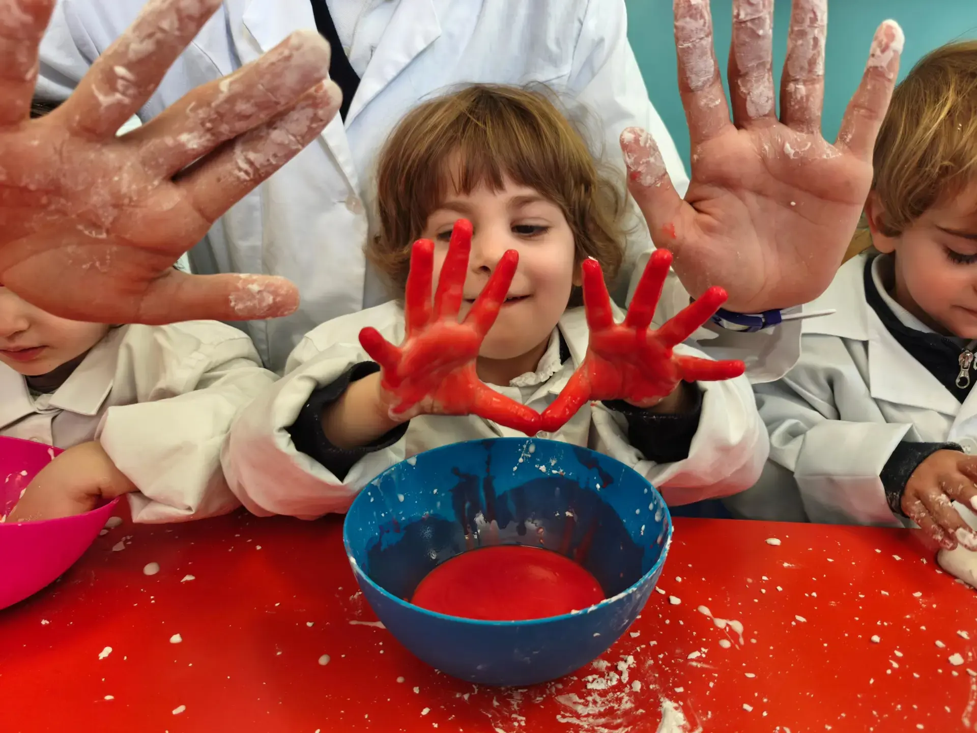young student showing paint-covered hands during a hands-on art activity