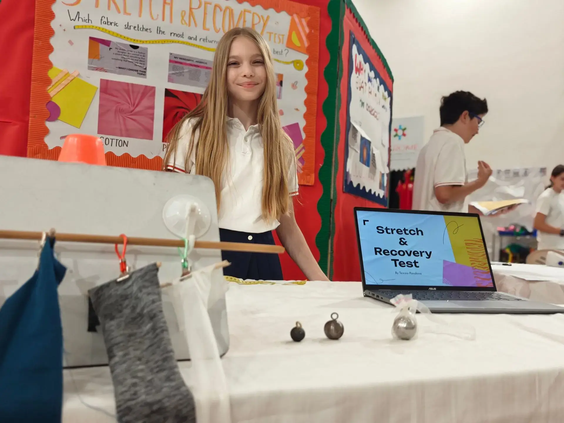 Student standing next to her project in a science fair