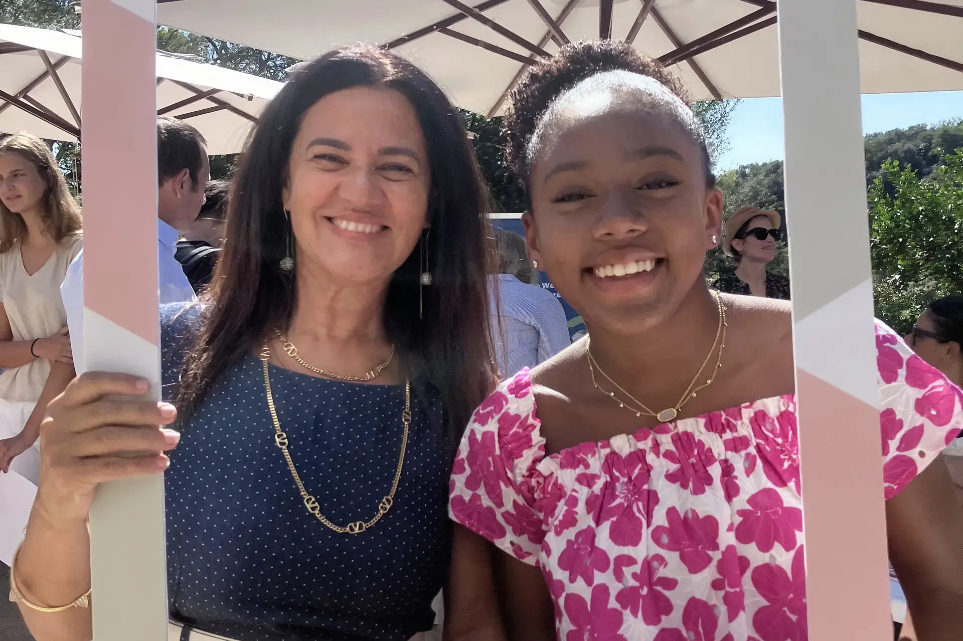 parent and student smiling together at a rome international school event under an outdoor umbrella