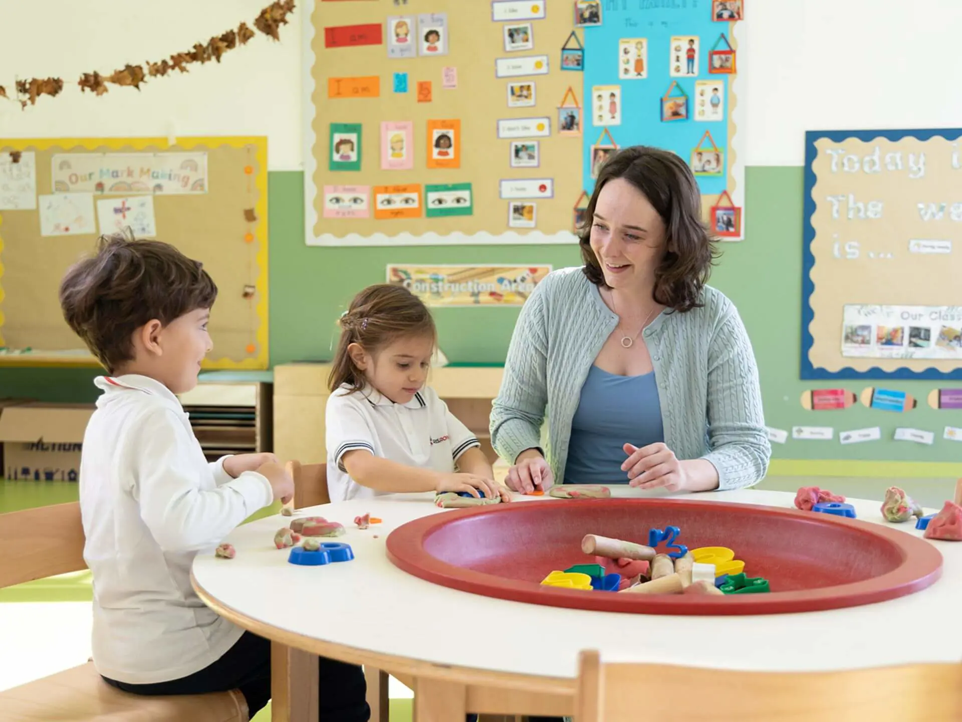 RIS students and teacher building with playdough