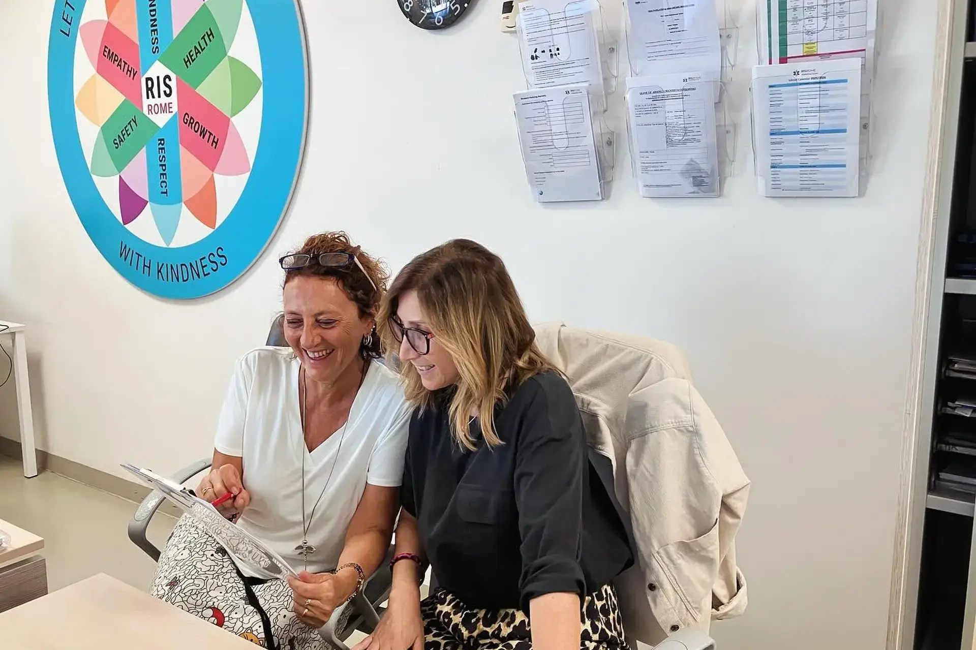 two staff members looking at a document together in an office