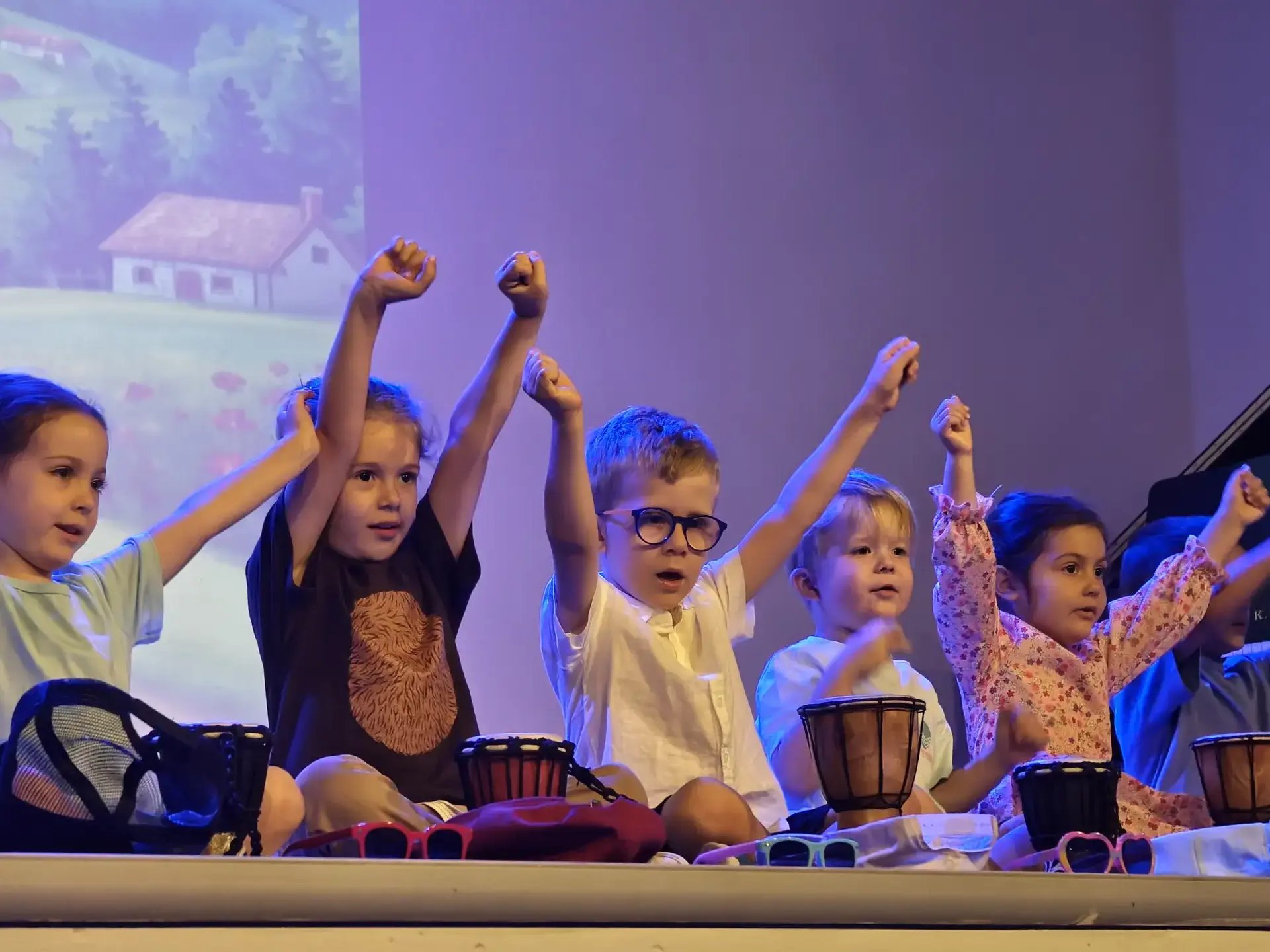 students playing drums and raising their hands during a music performance
