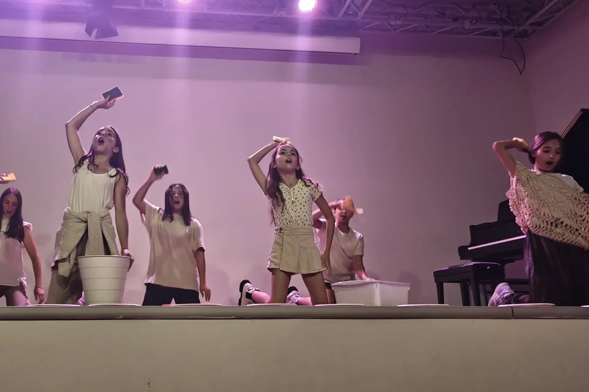 young students dancing together on stage during a performance.